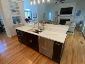 Modern kitchen with a central island, stainless steel appliances, and hardwood floors.