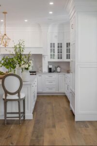 White kitchen with hardwood floors and a chair.
