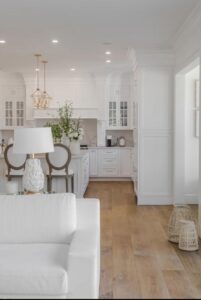 White kitchen with wood floors and white couch.