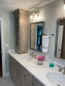 Double vanity with white countertop and cabinets.