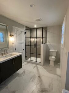 Modern bathroom with black framed shower and toilet.
