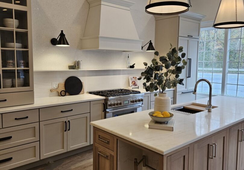 Showcasing a white kitchen with wooden floors and a stylish center island.