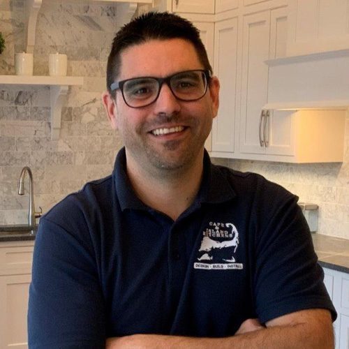 new-john A man in glasses and a blue shirt is smiling